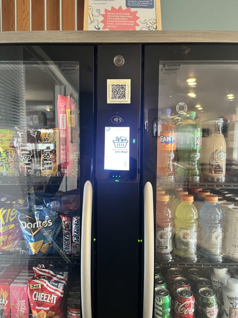 Close-up of a smart cooler touchscreen card reader and QR code for requests and support